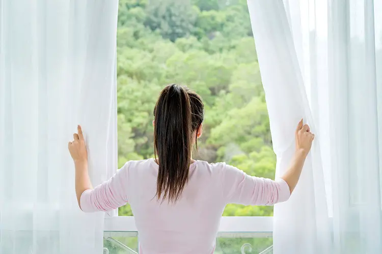 woman opening window